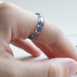Nature-inspired resin band with blue flowers and metallic silver flakes