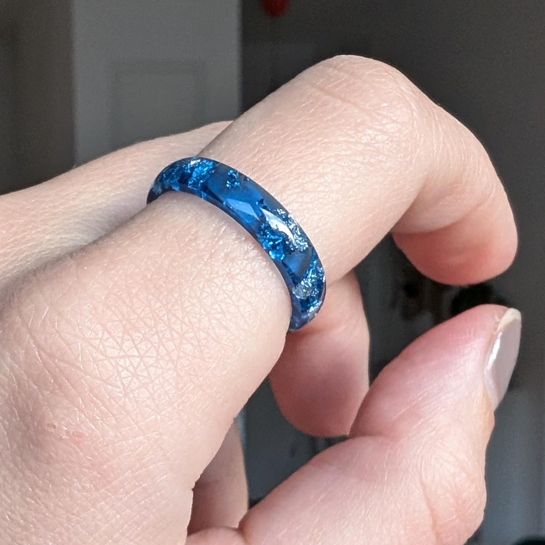 Blue and silver resin ring worn on hand