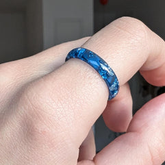 Blue and silver resin ring worn on hand