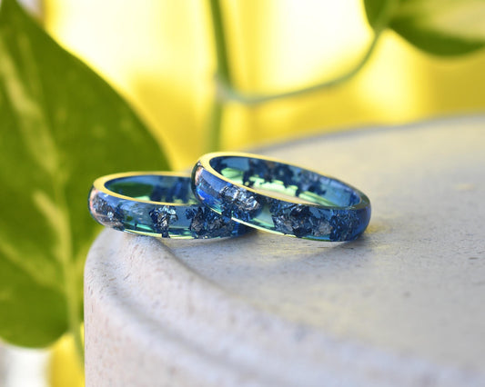 Navy blue resin ring with silver leaf on white background