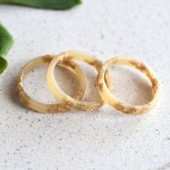 lose-up of gold flakes in nude resin band