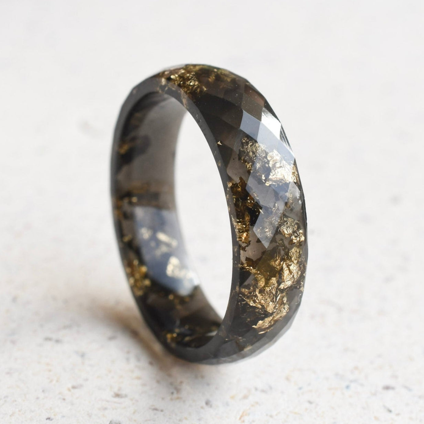 Faceted black resin stacking ring with metallic gold flakes handmade in Vienna