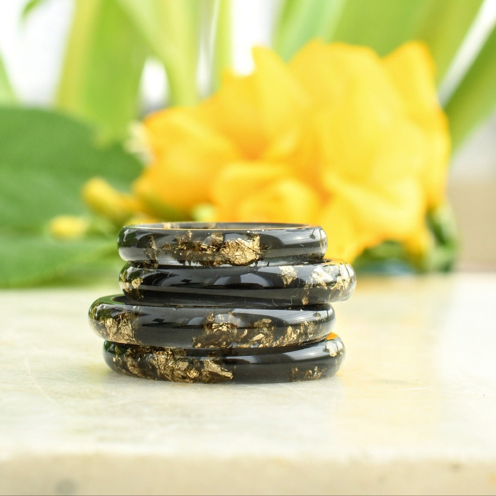 Smooth black resin ring with gold flakes handmade by Resity in Vienna