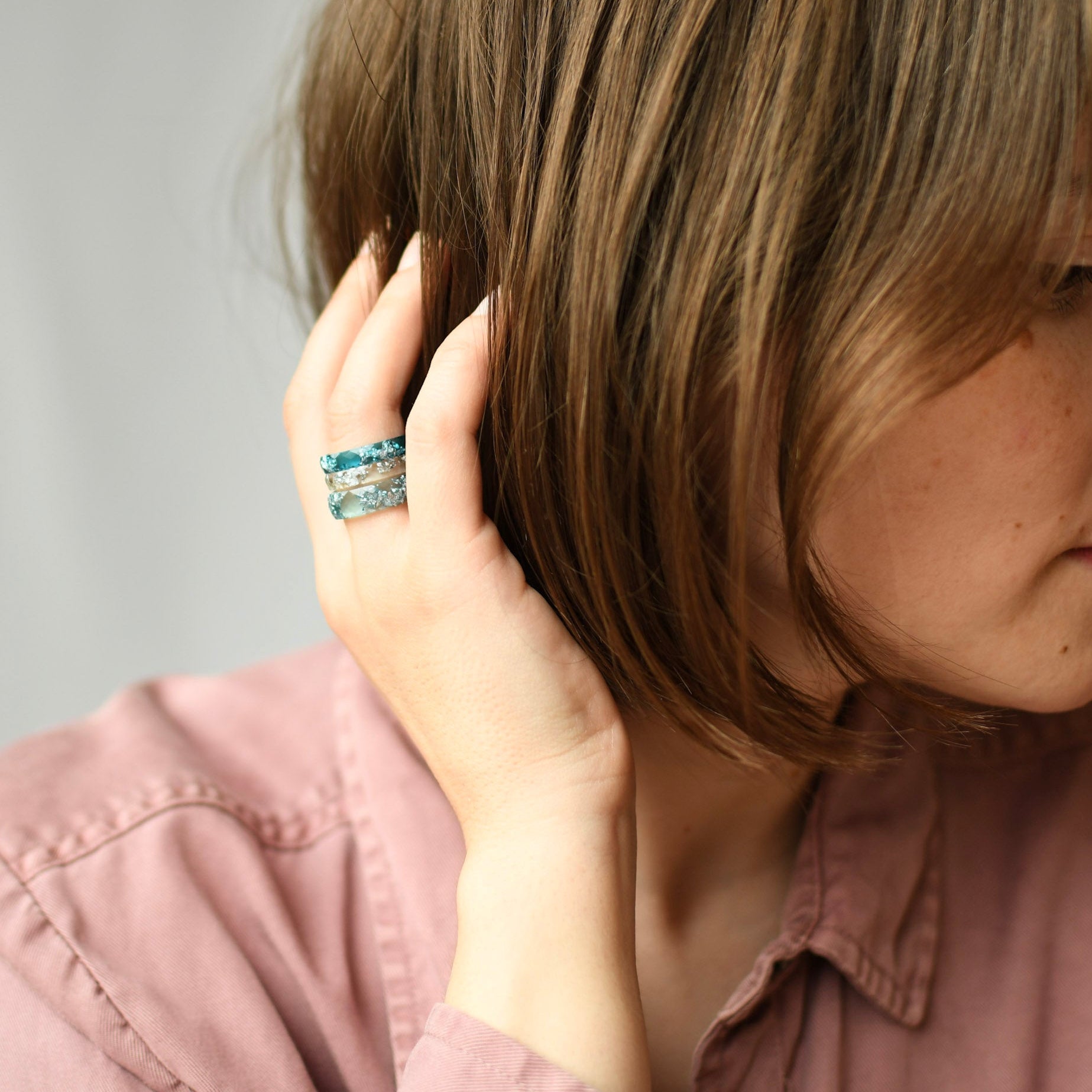 ocean stack resin rings worn on hand with cool blue tones