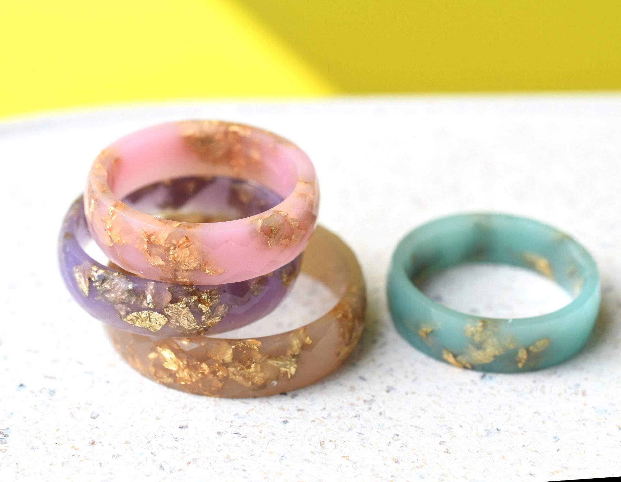 Close-up of gold flakes inside pastel resin handmade rings