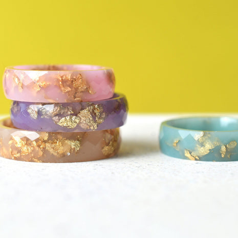 Pastel resin rings with gold leaf handmade by Resity in Vienna — pink, blue, purple, and nude