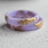 Close-up of delicate gold flakes in pastel purple resin ring