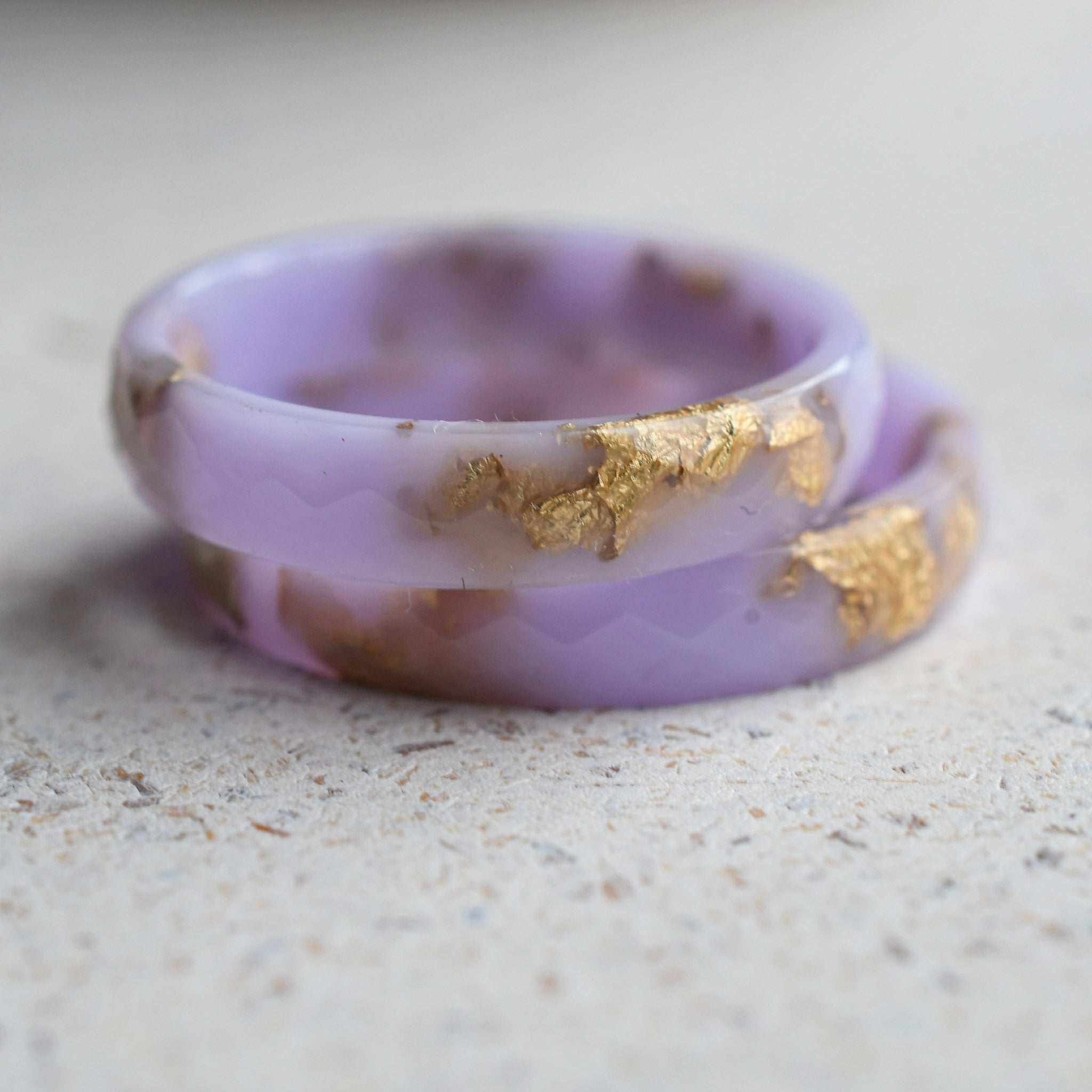 Close-up of delicate gold flakes in pastel purple resin ring