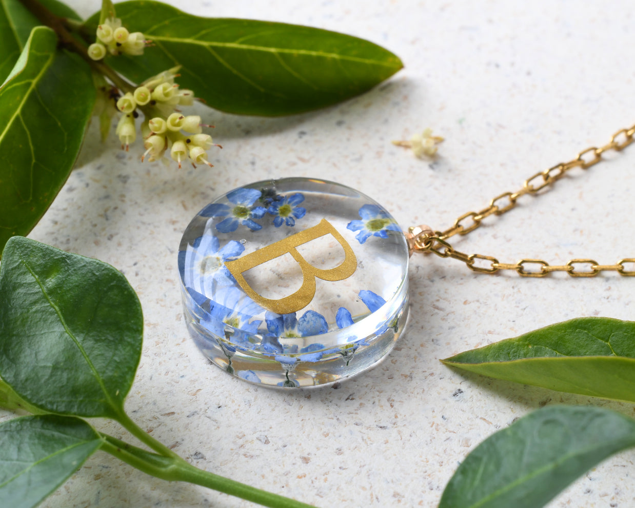 Personalized resin necklace with forget-me-not flowers and gold initial