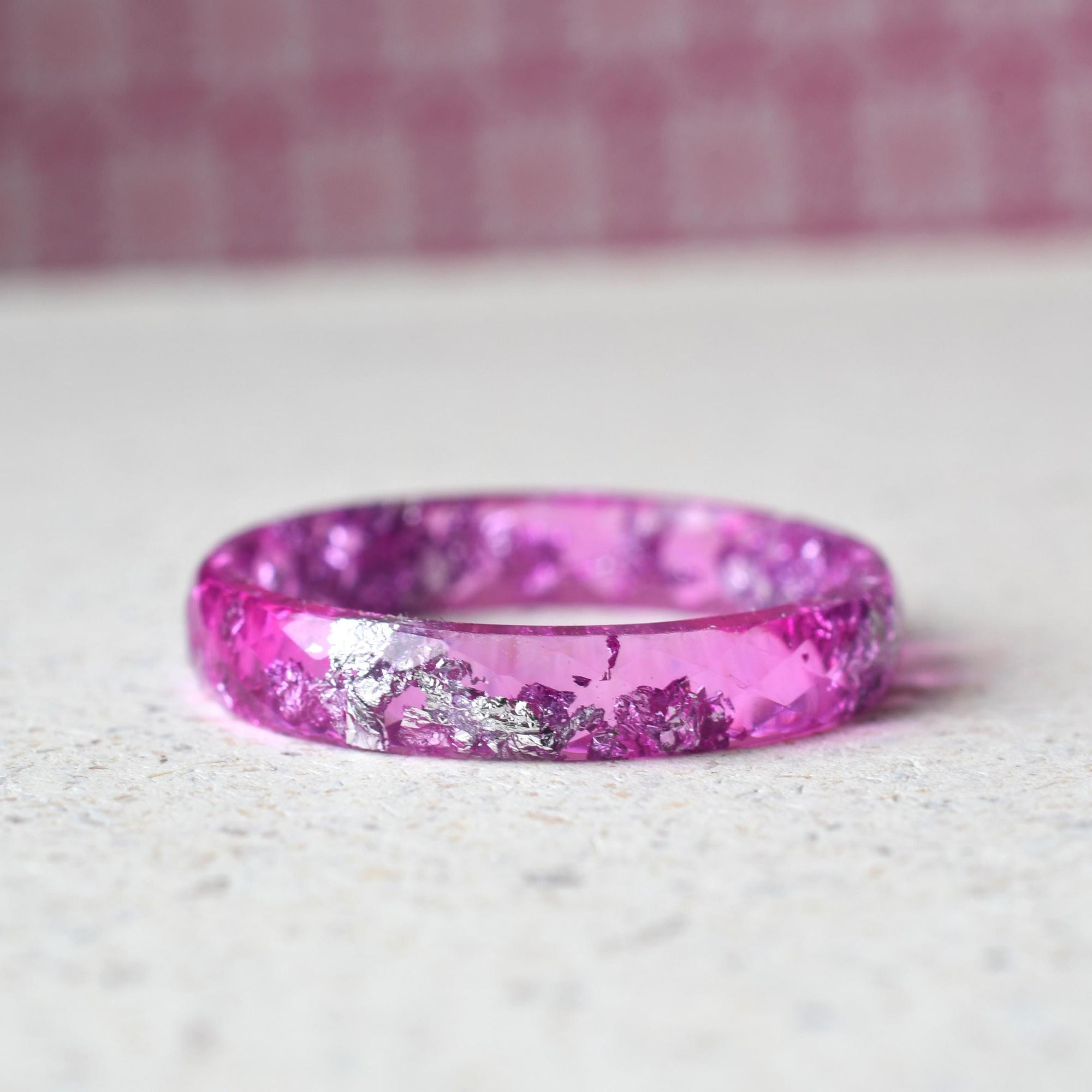 Close-up of real silver flakes inside faceted pink resin ring