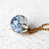 Close-up of preserved flower in spherical resin charm