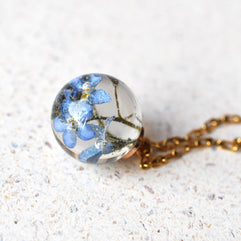 Close-up of preserved flower in spherical resin charm
