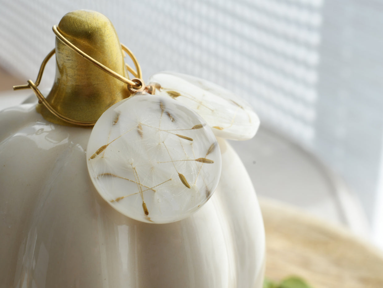 Resin dangle earrings with gold creole hoops and embedded dandelion seeds, handmade lightweight jewelry