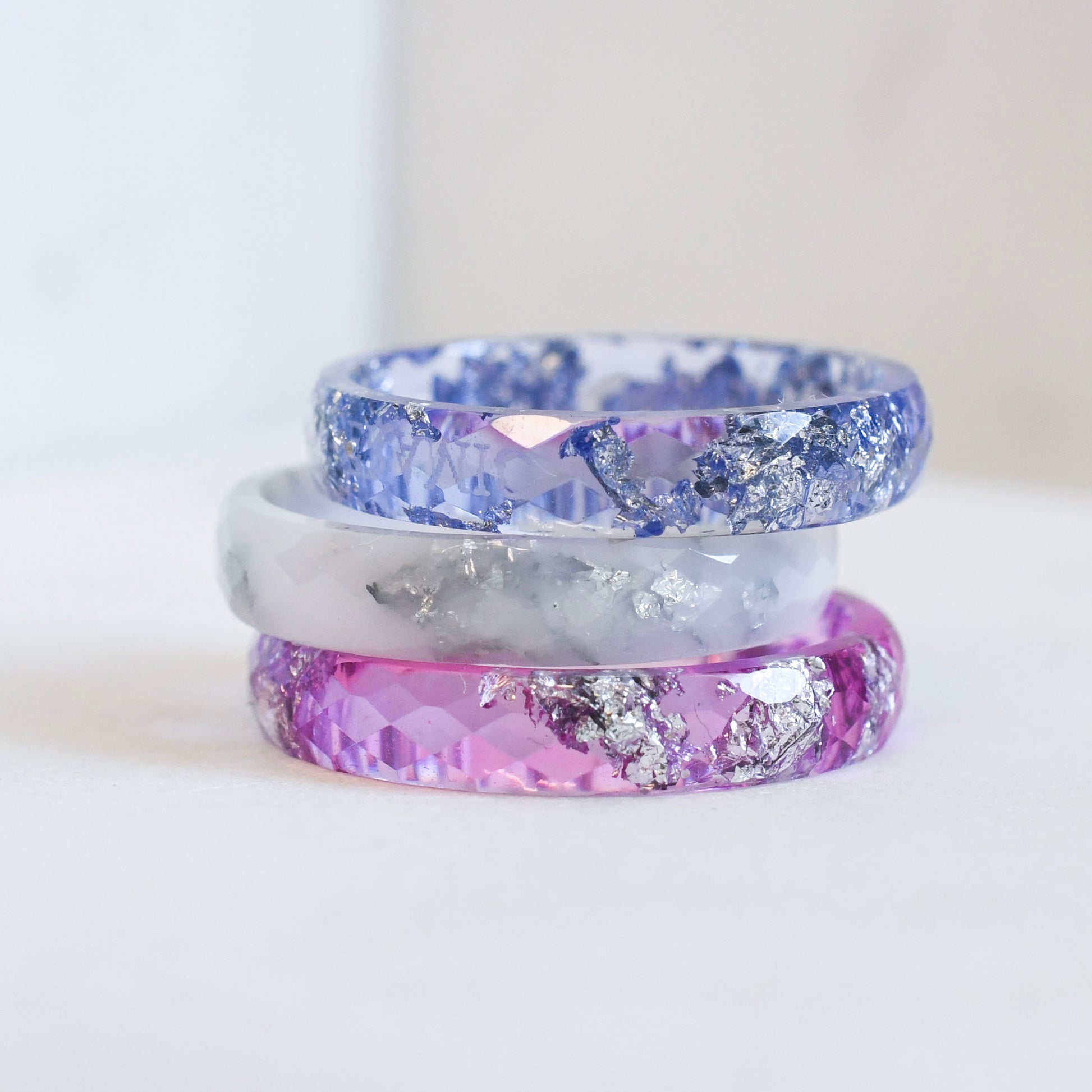 Resin stacking rings in blue, white, and purple worn together