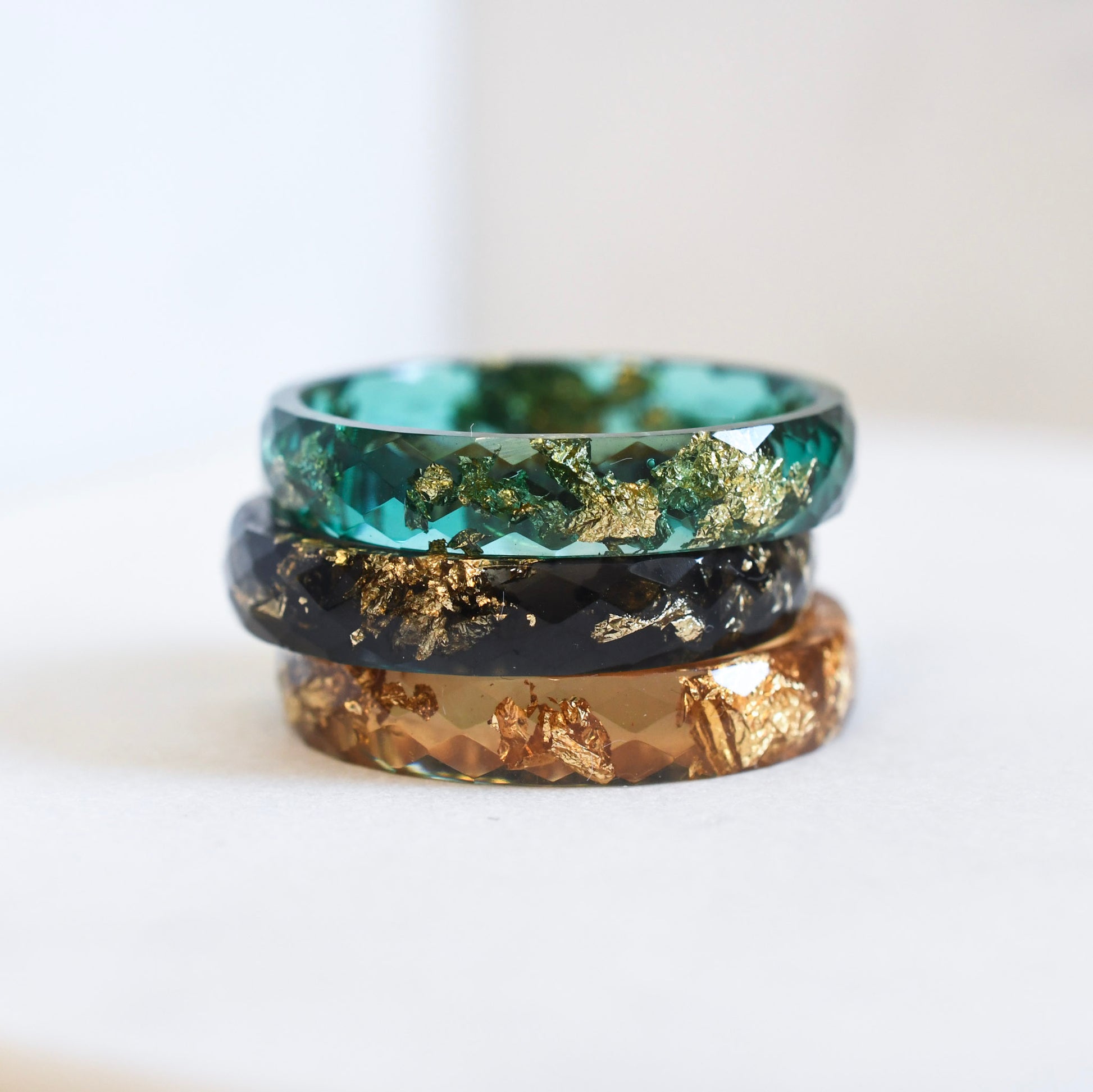 Resin stacking rings in green, amber, and black worn together