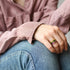 Three resin stacking rings worn on hand resting on knee