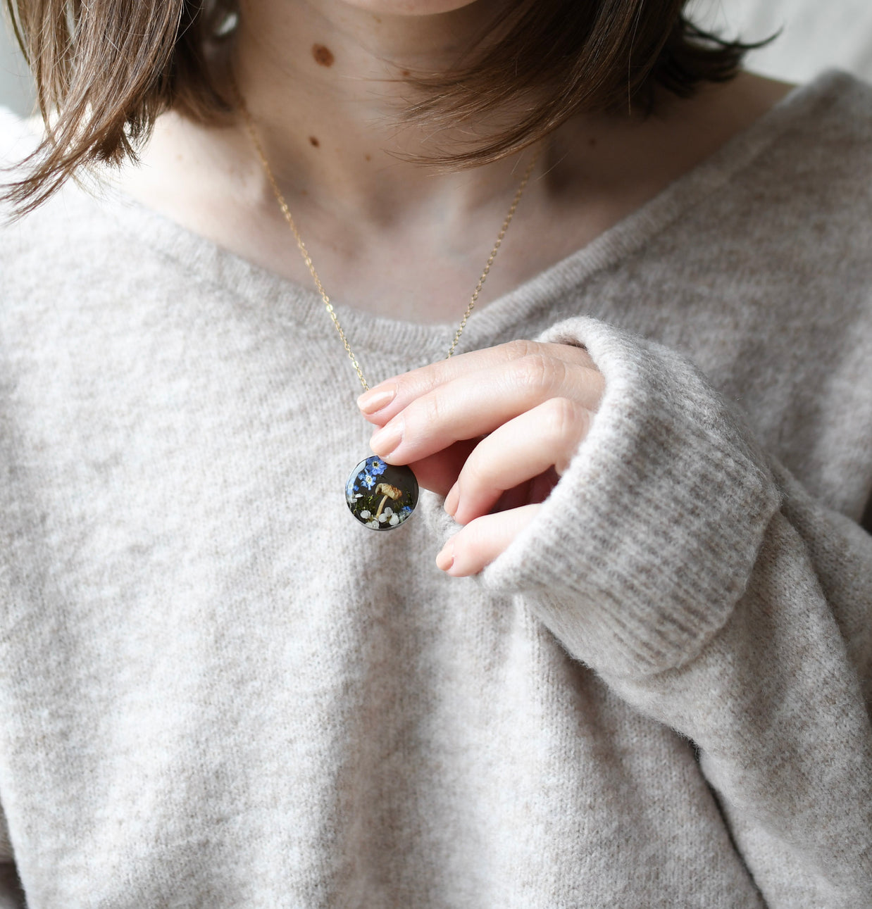 Terrarium-style resin necklace worn in minimalist styling — 20 mm pendant with botanical elements