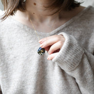Terrarium-style resin necklace worn in minimalist styling — 20 mm pendant with botanical elements