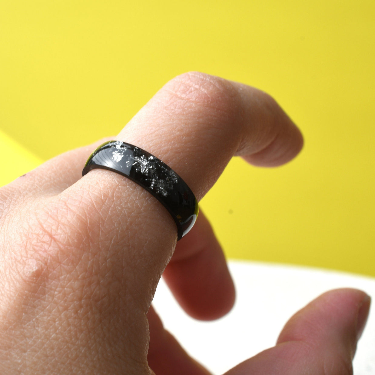Matching black and white resin couple rings worn on hands — handmade jewelry