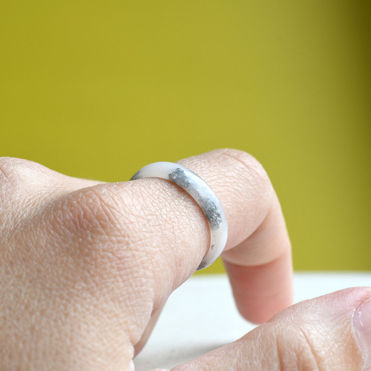 Matching white resin couple rings worn on hands — handmade jewelry
