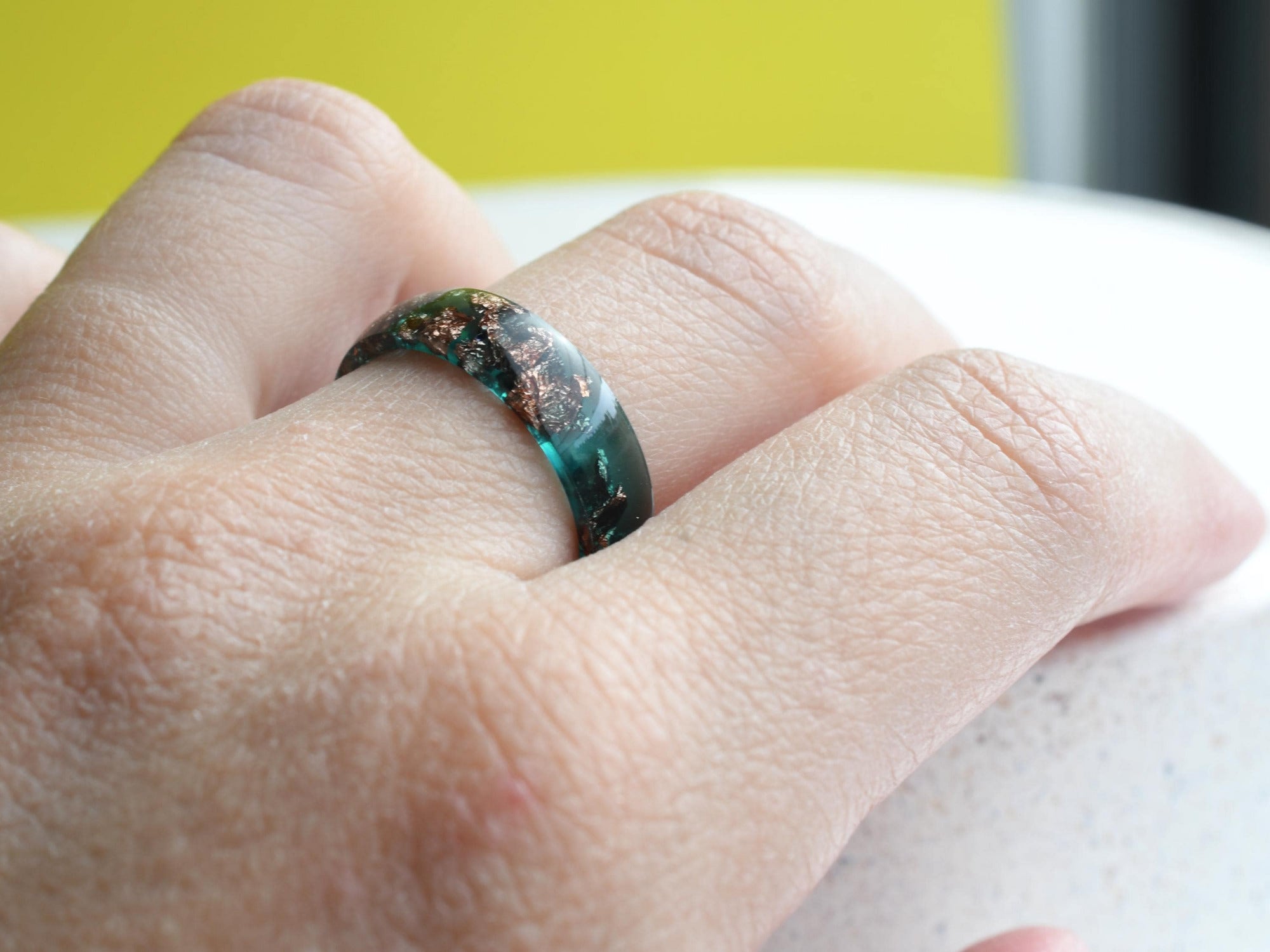 Handmade emerald green resin ring worn on hand — modern birthstone jewelry