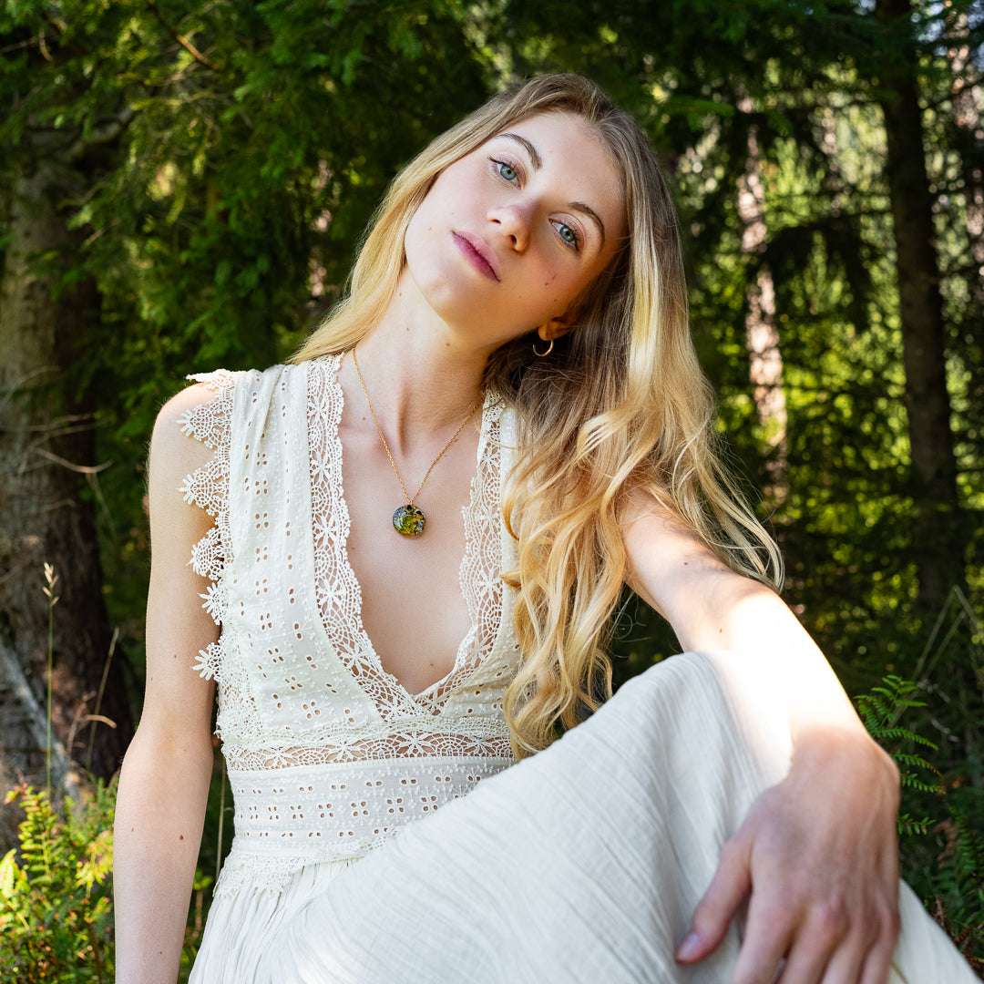 Forget-me-not and mushroom resin necklace worn on model — botanical jewelry