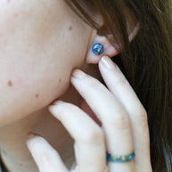 Blue and gold resin stud earrings worn on ear — hypoallergenic handmade jewelry