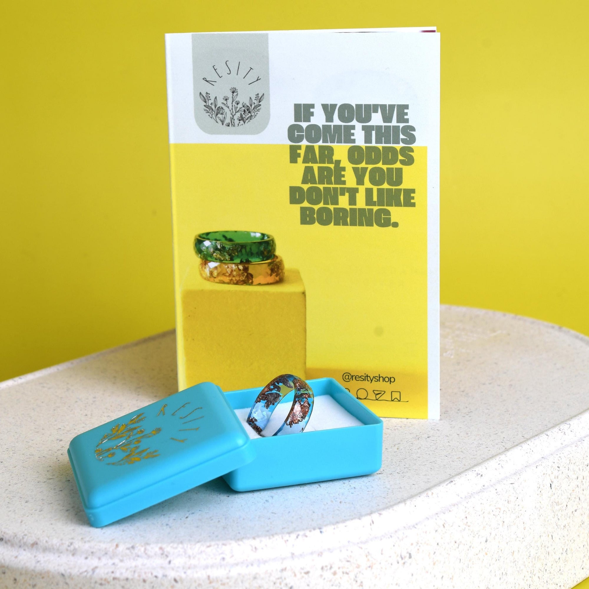 Gift presentation: cosmic violet resin ring nestled in a recycled kraft ring box with dried lavender sprigs.