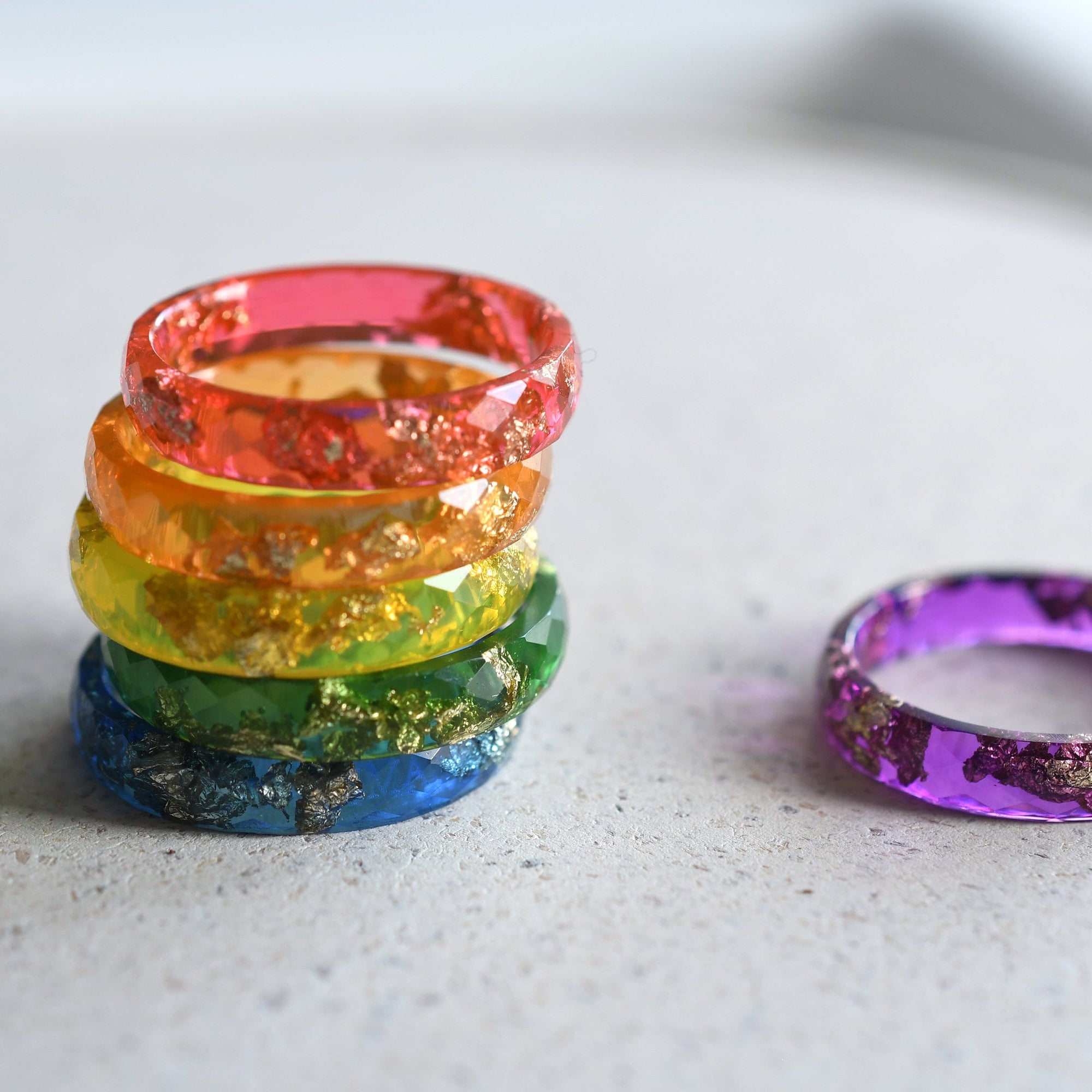 Stack of colorful resin rings on a light surface