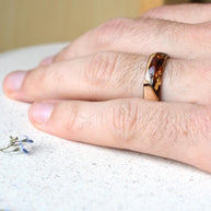 Wooden ring on a person's finger with a blurred background