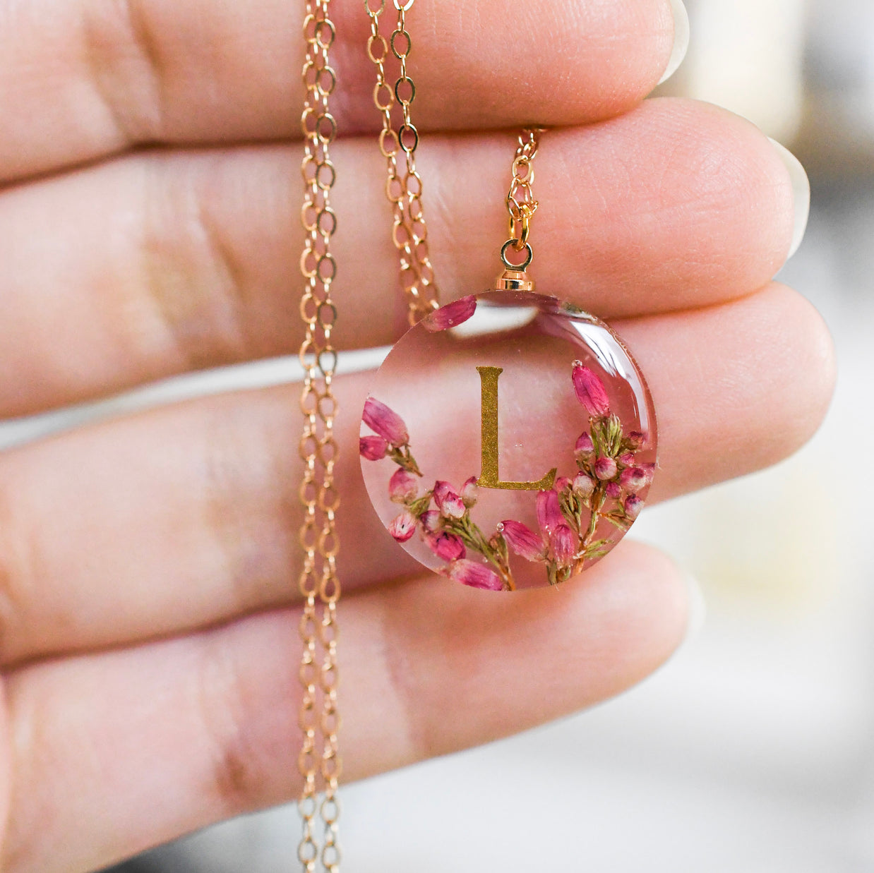 Personalized heather resin name necklace worn on hand — elegant handmade jewelry