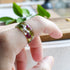 Handmade moss and alyssum resin ring worn on hand — nature-inspired design