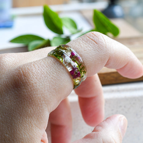 Handmade moss and alyssum resin ring worn on hand — nature-inspired design