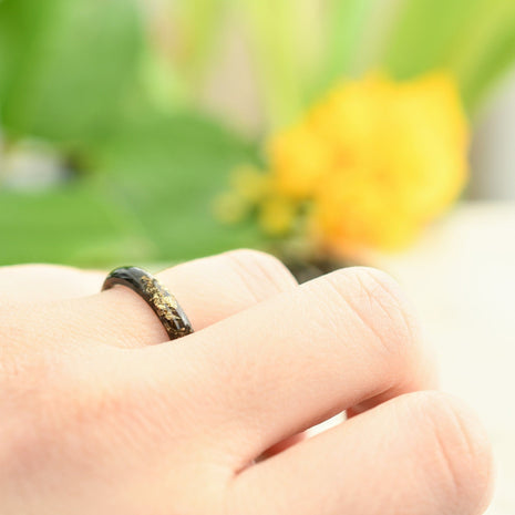 Smooth black resin ring worn on hand — minimalist modern design
