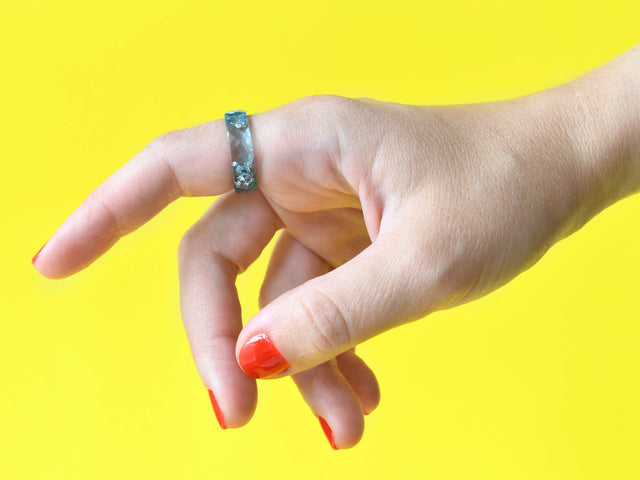Aquamarine resin ring with silver flakes worn on hand — unisex minimalist jewelry