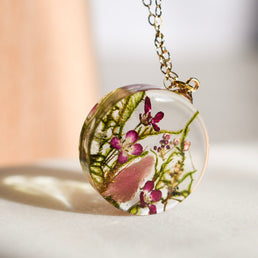 Moss and pink crystal resin necklace in sunlight