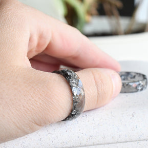 Grey resin ring with silver flakes worn on hand — modern handmade design
