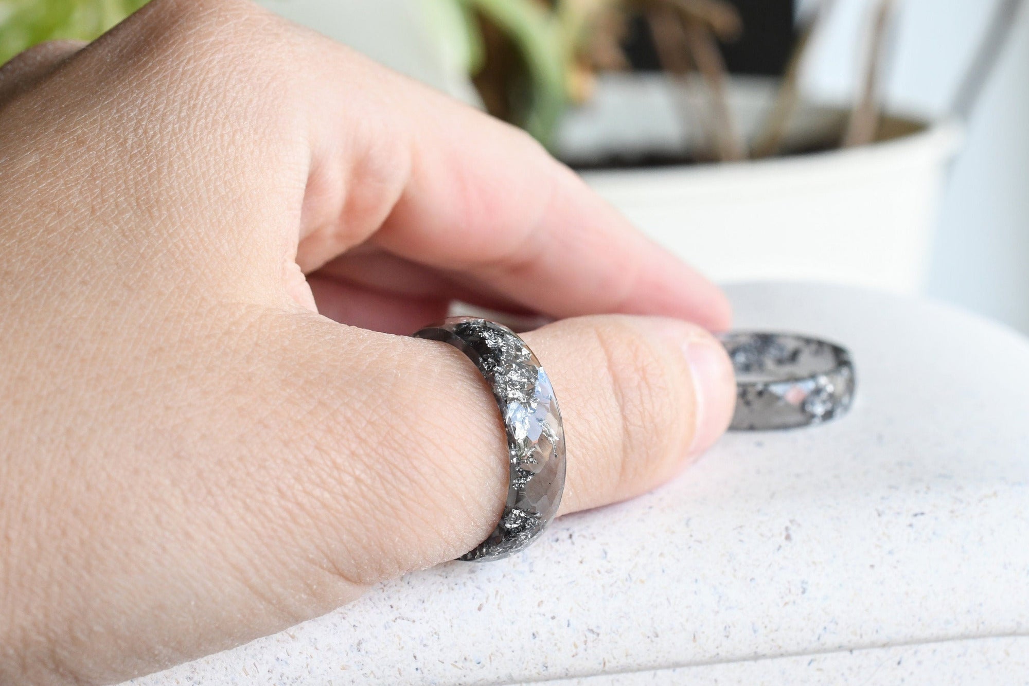 Grey resin ring with silver flakes worn on hand — modern handmade design