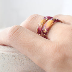 Hand wearing a ring with a gradient design on a light background