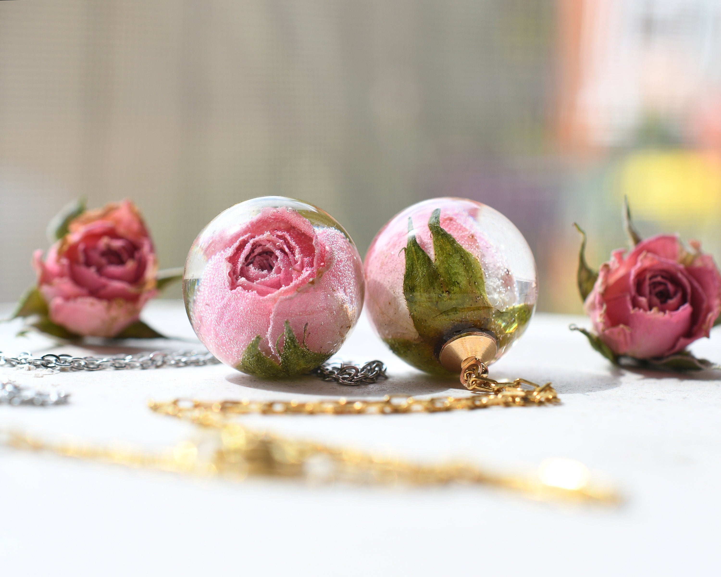 Necklace with real pink rosebud in resin sphere