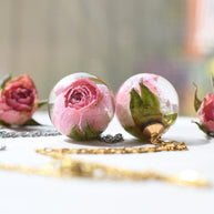 Necklace with real pink rosebud in resin sphere