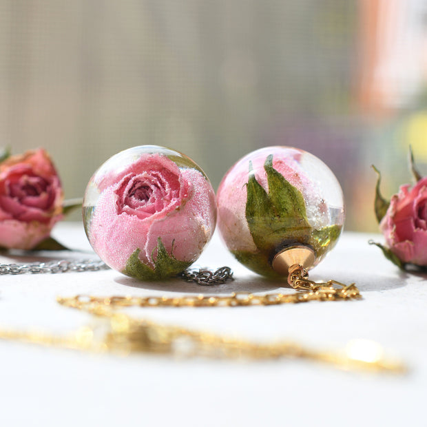 Necklace with real pink rosebud in resin sphere