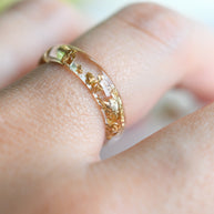 Gold ring on a person's finger with a blurred background