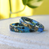 Matching sapphire blue resin couple rings with gold leaf handmade by Resity in Vienna