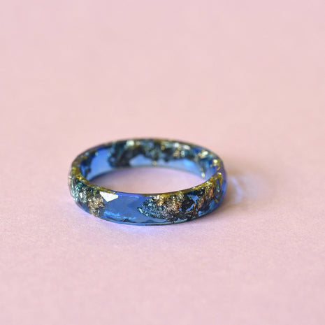 Close-up of gold flakes in sapphire blue faceted resin ring handmade in Vienna