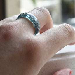 Aquamarine and silver resin ring worn on hand