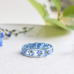 Thin resin ring with preserved blue flowers and silver leaf inclusions