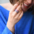 pink slim faceted resin ring with silver flake on woman´s hand