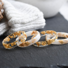 White and transparent faceted resin ring set with metallic gold flakes — handmade in Vienna by Resity