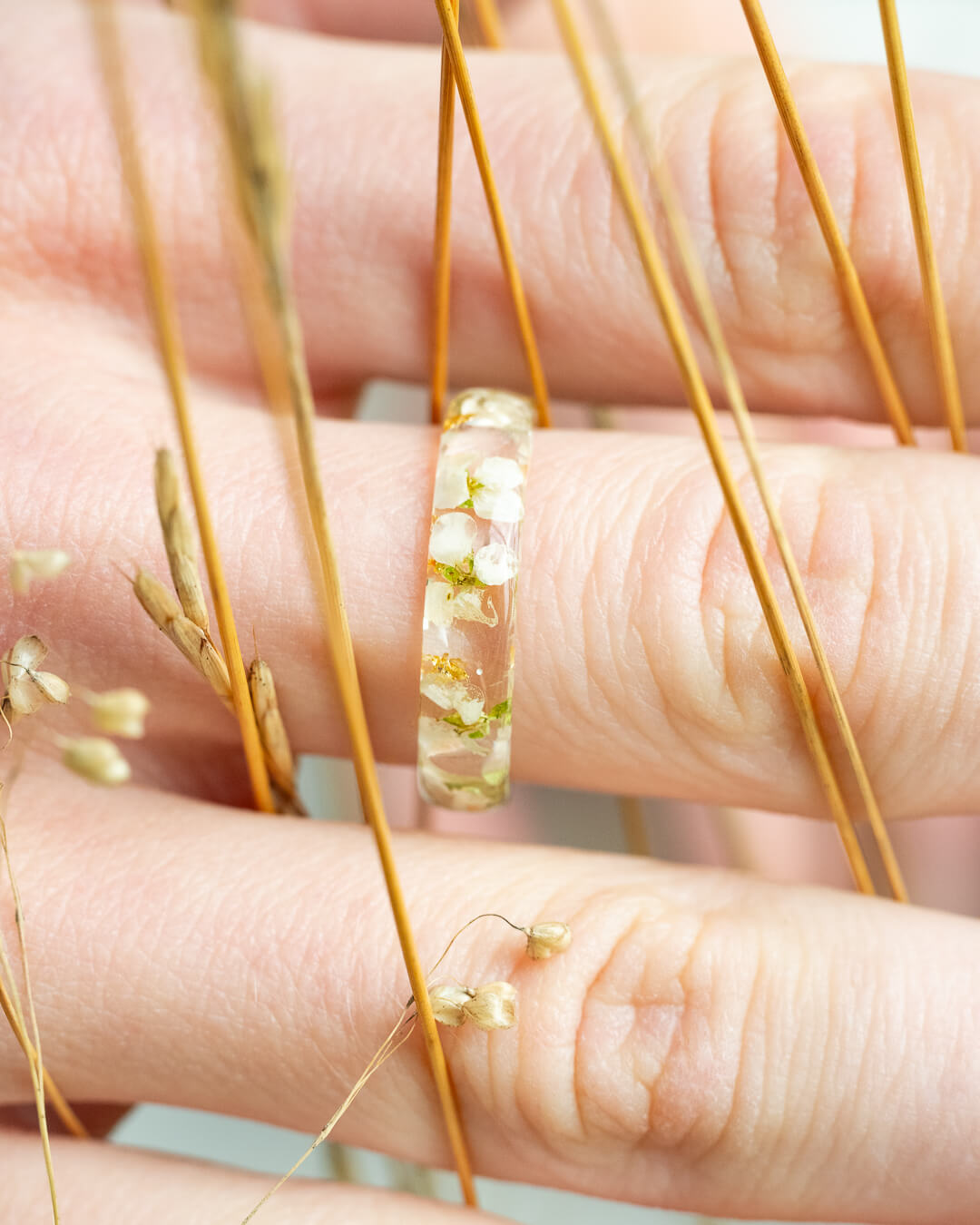 Close-up of white flower resin ring – handmade botanical jewelry by Resity, captured in natural light.